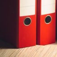 pexels photo 265024 265024 Close-up of two red lever arch files on a wooden desk in a modern office setting.